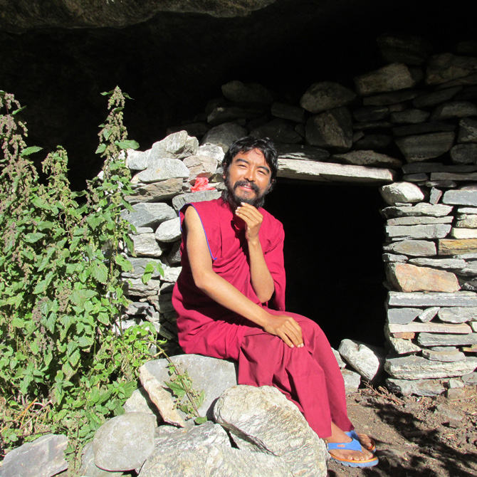 Mingyur Rinpoche sitting outside a retreat cave. Pho
